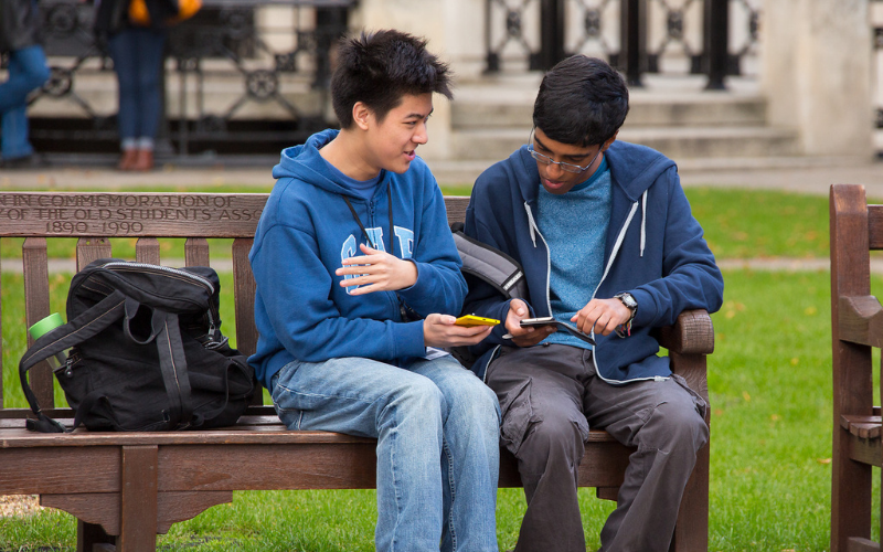 Two male students on their phones in the Front Quad
