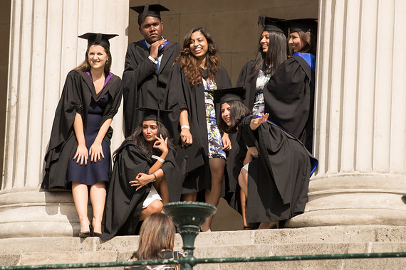 Students in graduation gowns on the UCL portico