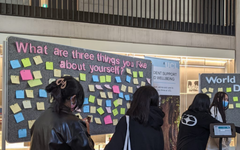 Students around a pin board with post its