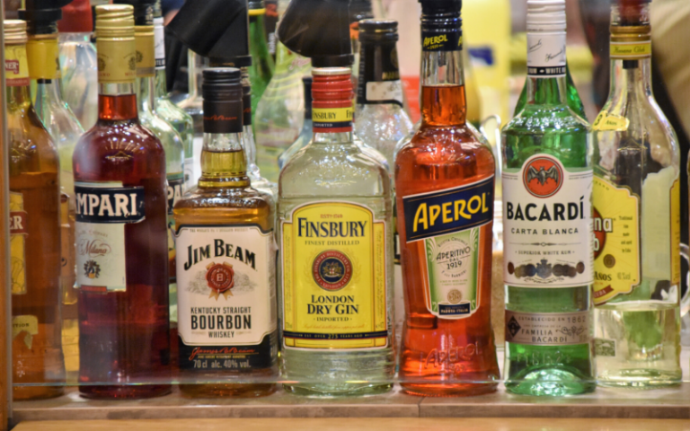 Selection of bottled alcohol spirits lined up on a shelf