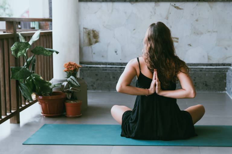 Woman wearing black shirt sitting on yoga mat