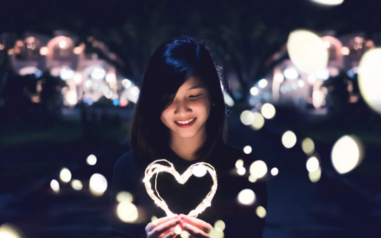 Girl holding heart shaped fairy lights