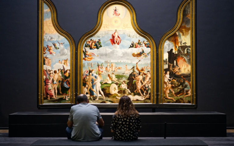 Two people looking at a painting in the Rijksmuseum, Amsterdam