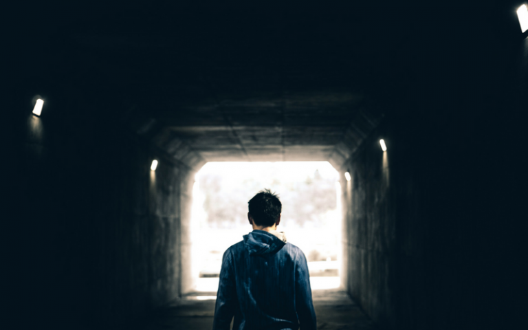 Man walking out of tunnel into light