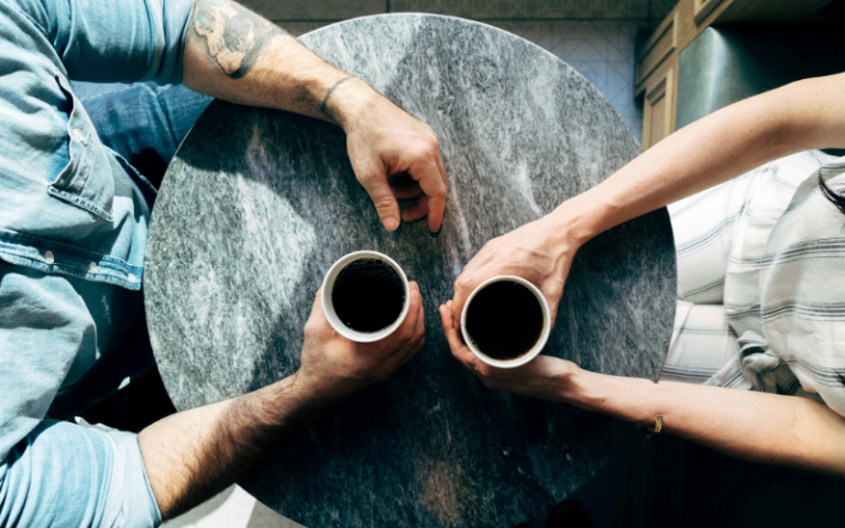 Two people sharing coffee over a table