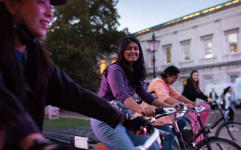 A group of people on stationary bikes, cycling to power a cycle cinema