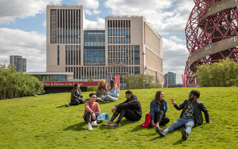 Students sat on grass in the Olympic Park
