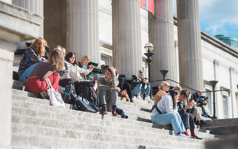 Students sat socialising on Portico steps