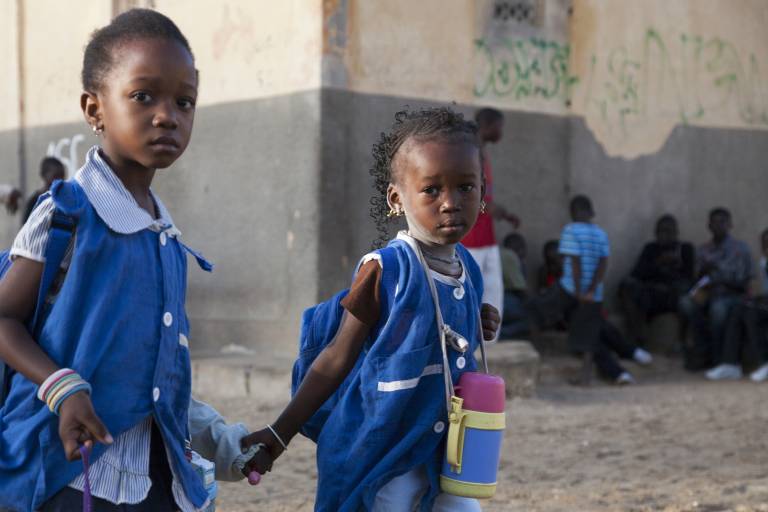 Two schoolchildren wearing blue uniforms