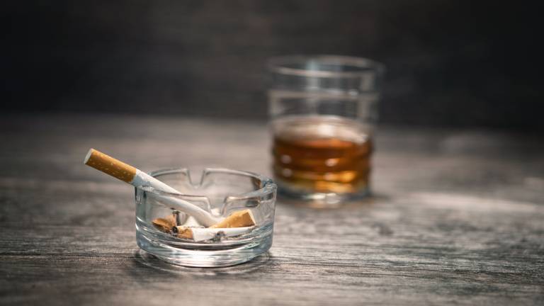 Small glass ash-tray with smoking cigarette