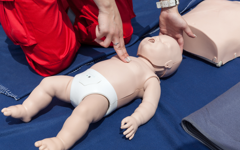An image of a plastic baby having CPR
