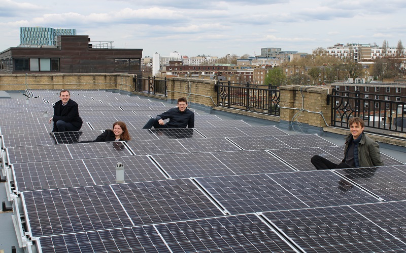 A group of students on a UCL roof with solar panels