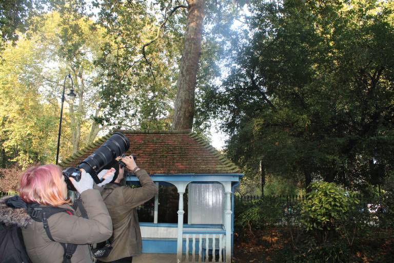 Two students using camera lenses and binoculars to see the birds of Woburn Square
