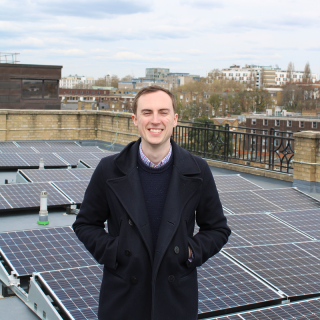 Jamie from the Clean Energy Projects Society in front of solar panels