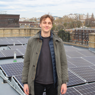 Paul from the Clean Energy Projects Society in front of solar panels