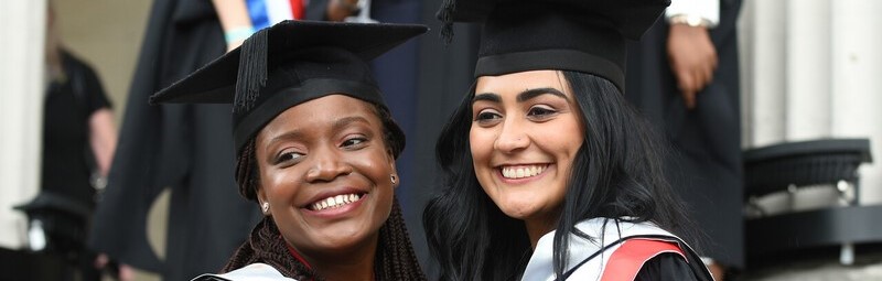 two students in graduation gowns