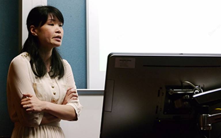 Beatrice Lok standing in front of a computer and projector screen