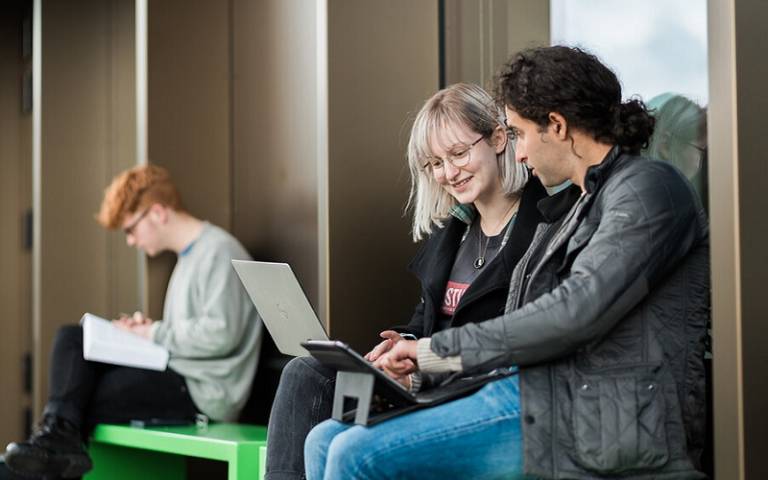 Two students sitting with a laptop
