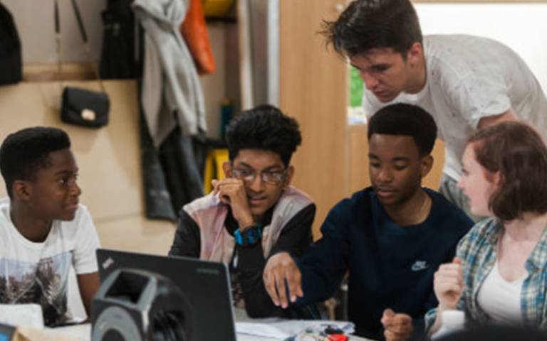 students working together around a computer