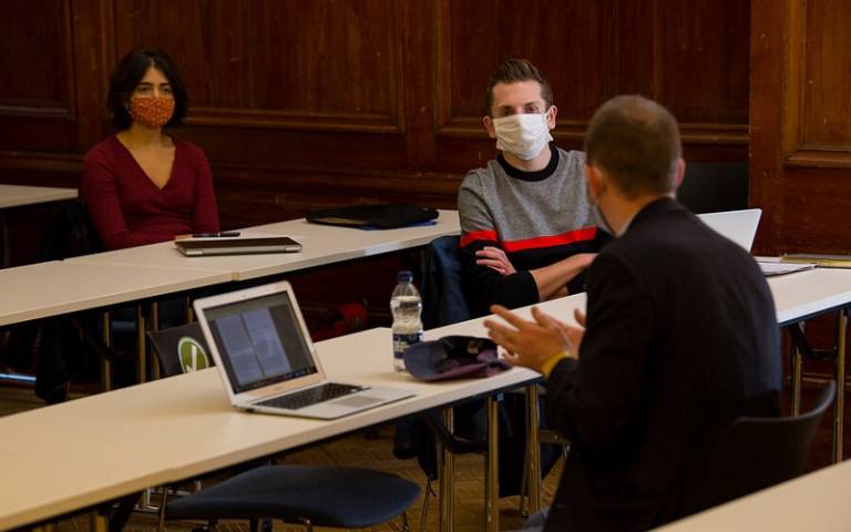 Lecturer and two students in masks in discussion in class