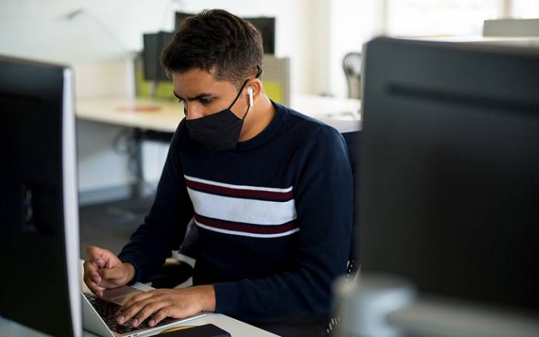 Student wearing mask working at a PC