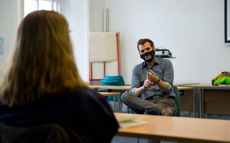 Teacher in mask in discussion with a student