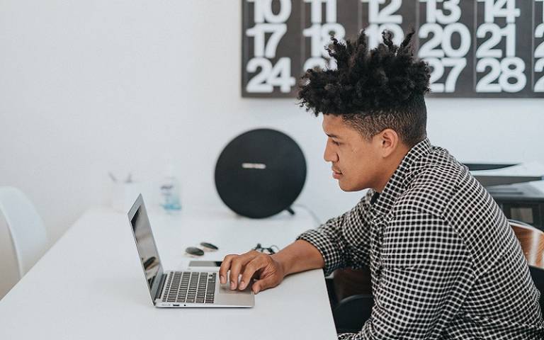 Student with laptop and clock. Credit: Nathan Dumlao / Unsplash