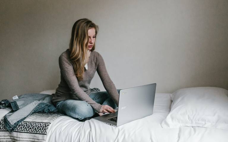 Student with laptop on a bed. Image credit: Andrew Neel / Unsplash.com