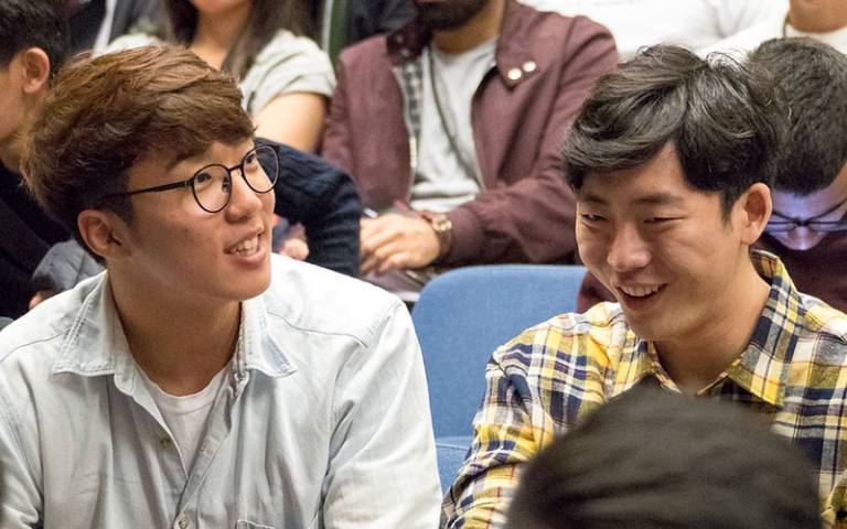 two students smiling in a lecture hall