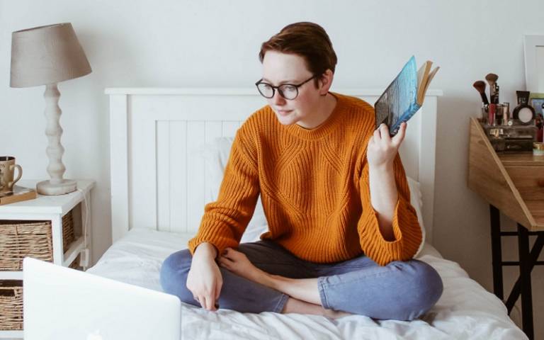 Image of woman sitting on bed with laptop. Credit: Sincerely Media/Unsplash