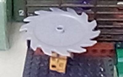 A lego person with a circular saw blade spinning above their head