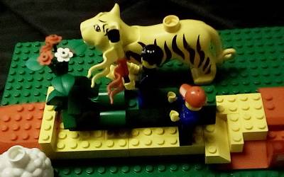 a lego model with people, animals and plants in a boat