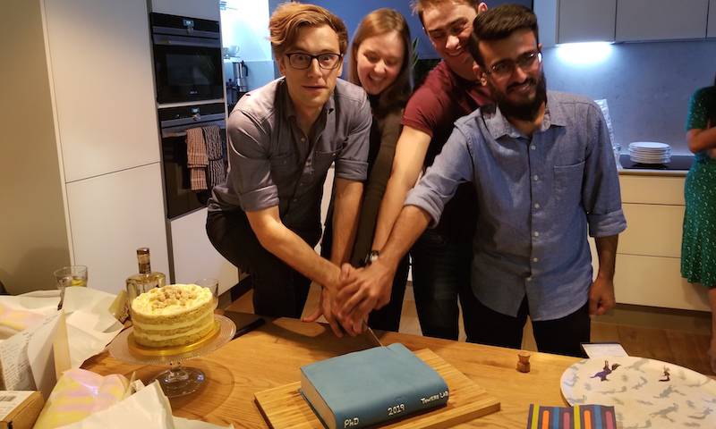 Cutting the amazing cakes to celebrate the 4 PhD students finishing together