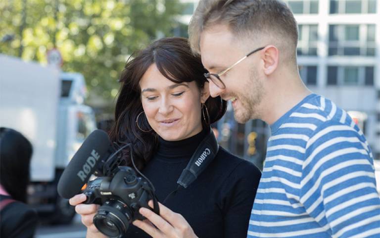 Photo of two members of the internal comms community of practice looking at a camera