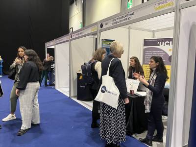 A photo showing a conference space with groups of people around the exhibition booths