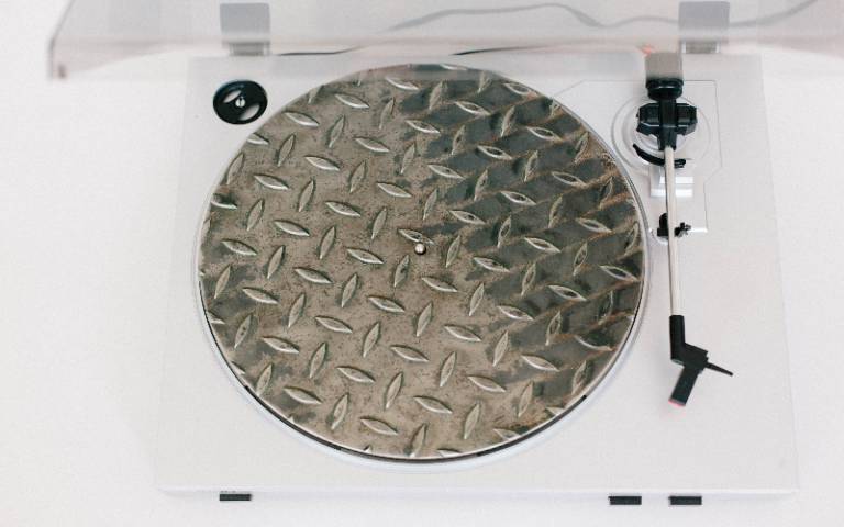An aerial view of a record player where the turntable appears to be made from a manhole cover