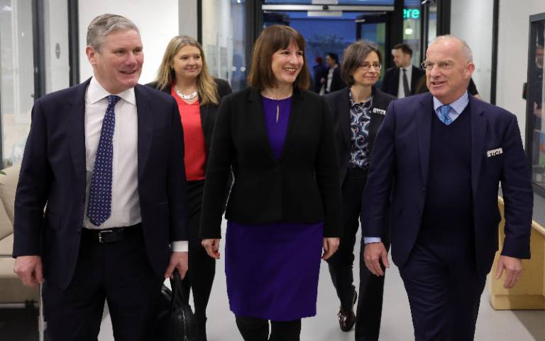 Forground: Sir Keir Starmer, Rachel Reeves MP, Dr Michael Spence with Kirsty Walker and Prof Paola Lettieri just behind them, walking towards the camera down a wide corridor in a science lab area environment
