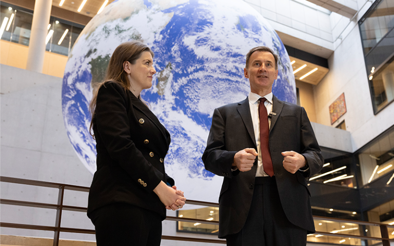 Secretary of State Michelle Donelan stands next to Chancellor Jeremy Hunt in front of a giant globe hanging above them 