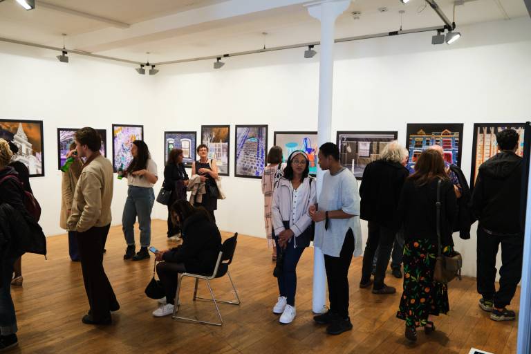 Photograph of a mixed group of people in a gallery at an exhibition of the RGB East project which explored colour perception and eyesight