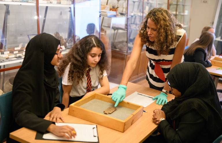 Teacher explains Egyptian artefact to group of students