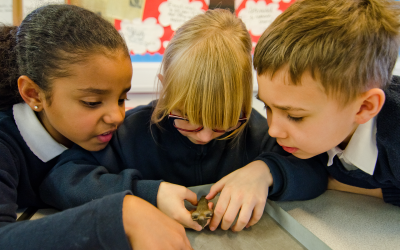 primary school children handling UCL institute of archaeology objects as part of a ucl workshop.