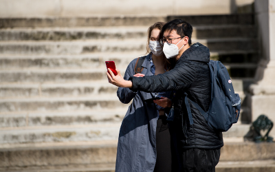 Two students in masks take a selfie.