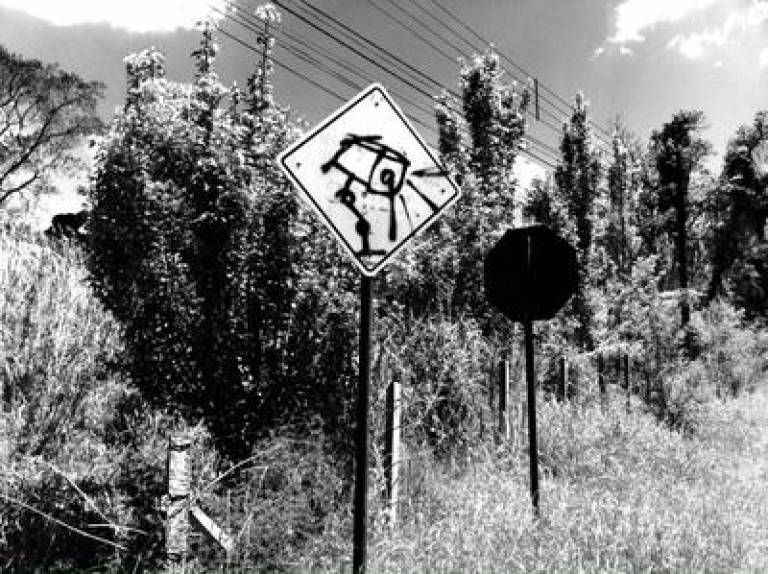 Surveillance camera graffiti on road sign