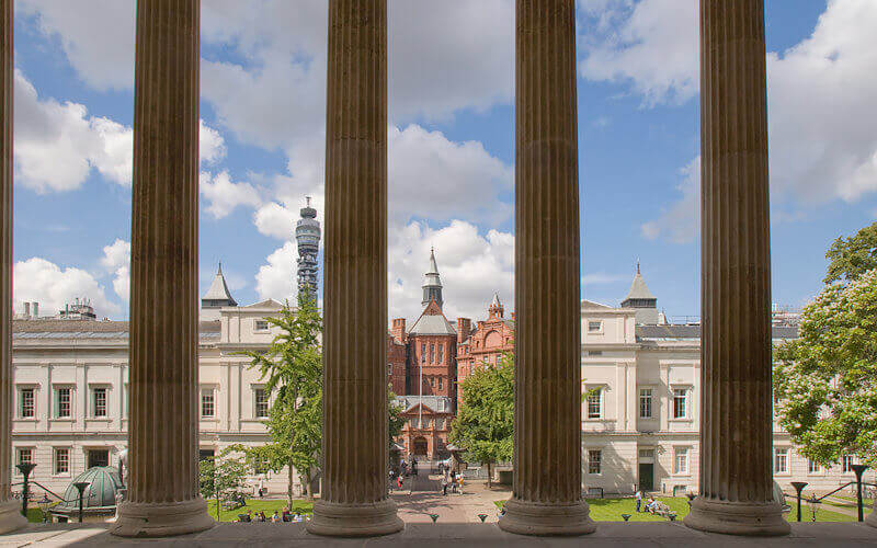 A view of the UCL Cruciform Building through the tall pillars of the Portico Building