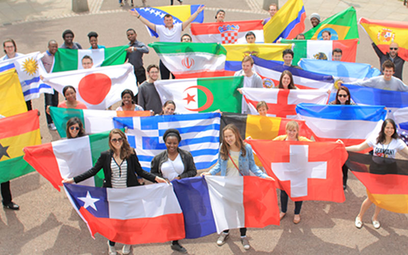 A group of UCL international students holding their country flags